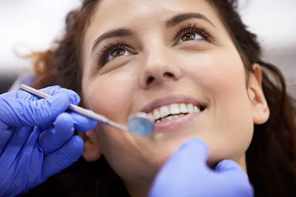 Smiling woman receiving dental cleaning at Capitol Square Dental 