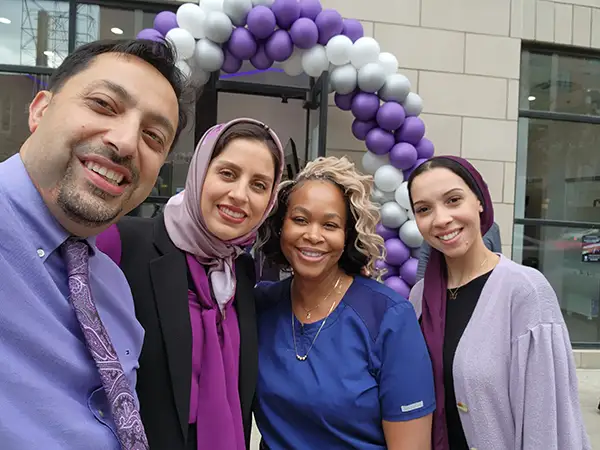 Dr. Mehrdad Safavian smiling with a group in front of Capitol Square Dental