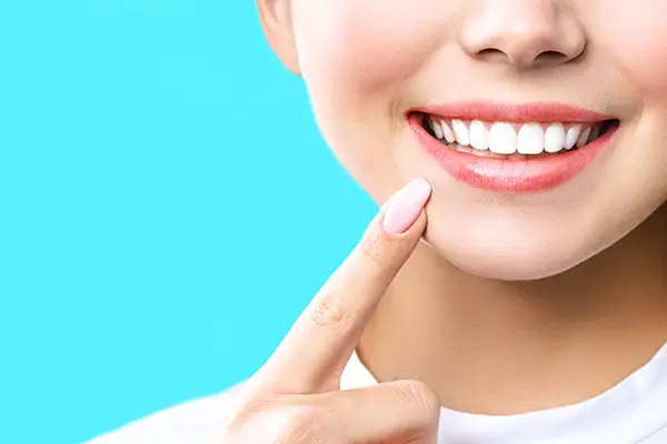 Woman pointing to her white teeth from Capitol Square Dental 