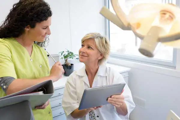 A dentist consulting with a hygienist in the office