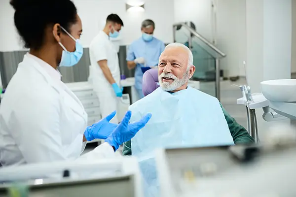 Man at Capitol Square Dental asking 'How long do dentures last?'.