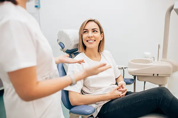 Woman at Capitol Square Dental asking 'Can Invisalign Fix my Overbite?'.